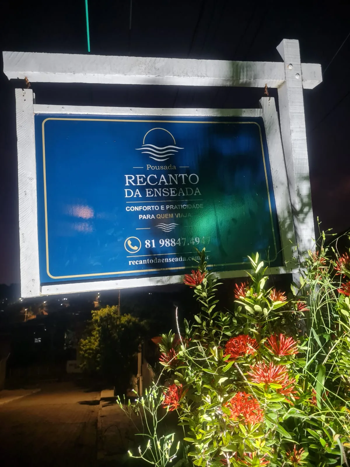 Placa da pousada iluminada à noite